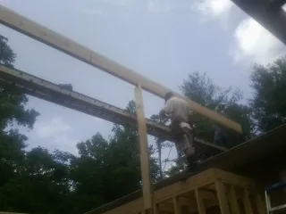 Carpenter setting a ridge beam over a new addition frame — Ice Dam Removal by Roofing Brothers in Valparaiso