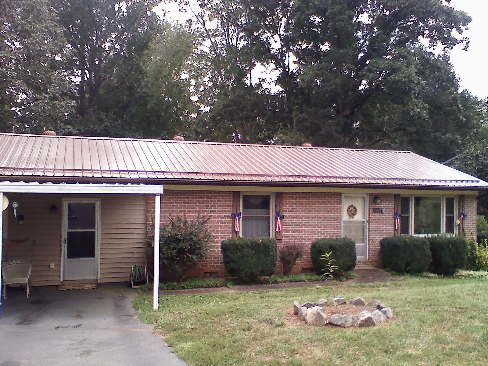Bronze metal roof and carport on a brick ranch home — Roof Repair work by our crew in Valparaiso